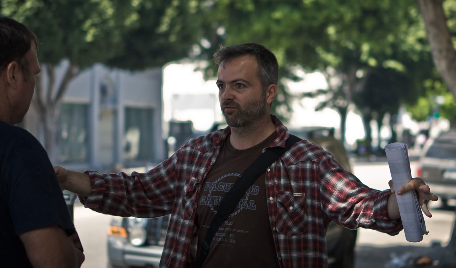 Efram Potelle directing on location, pages in hand.