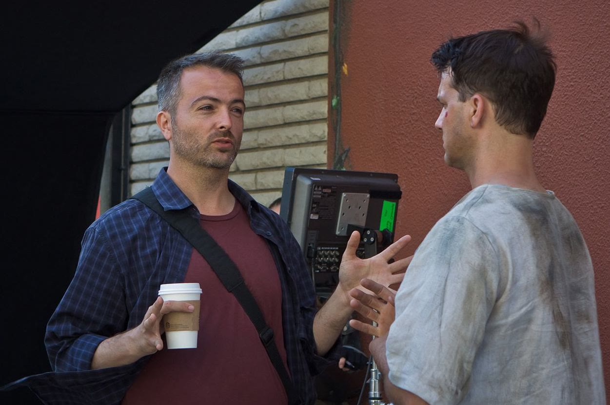 Efram Potelle talking with the lead actor at the monitor on set.