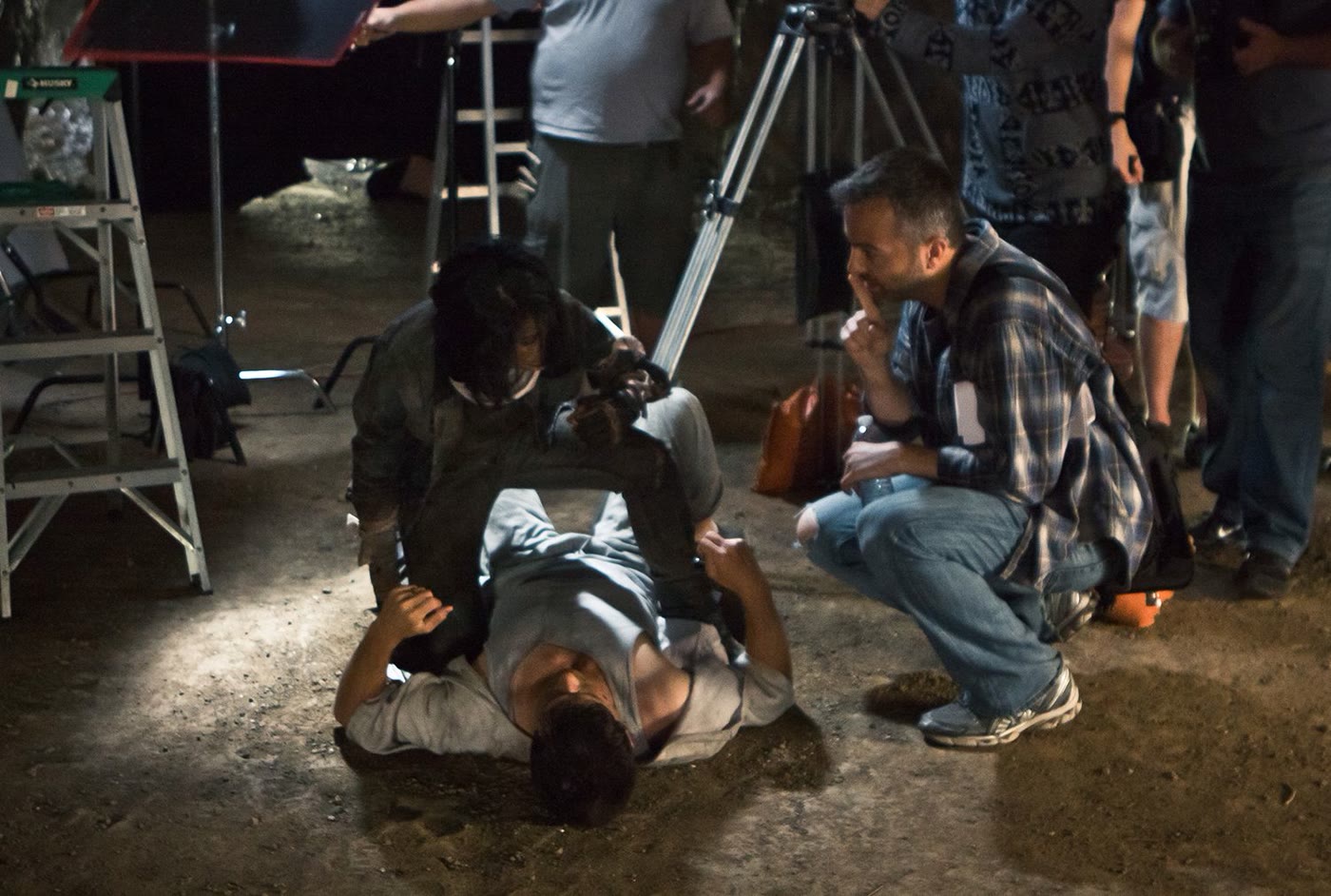 The full crew gathered around the actors on the cave set.