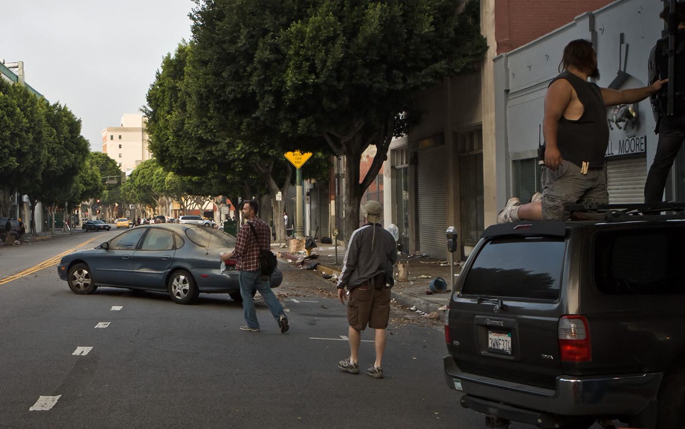 The deserted street location, seen wide with crew at work.