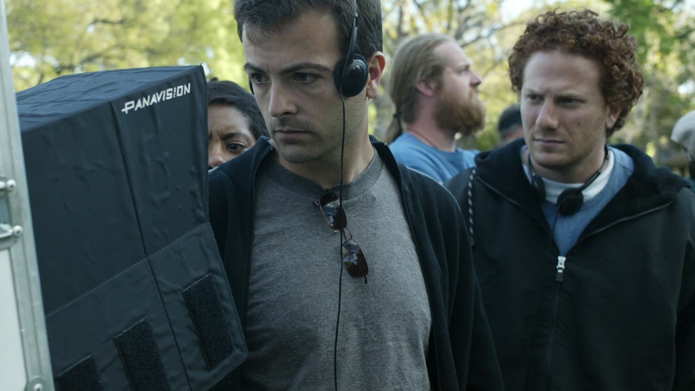 Efram Potelle at the monitor beside a Panavision camera on set.